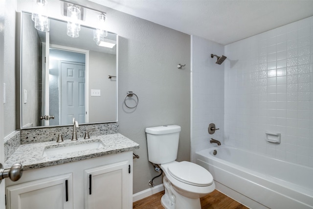 full bathroom with hardwood / wood-style floors, vanity, toilet, and tiled shower / bath combo