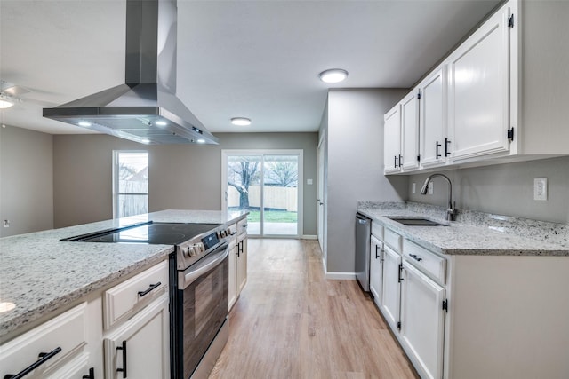 kitchen featuring light stone countertops, stainless steel appliances, white cabinetry, and wall chimney range hood