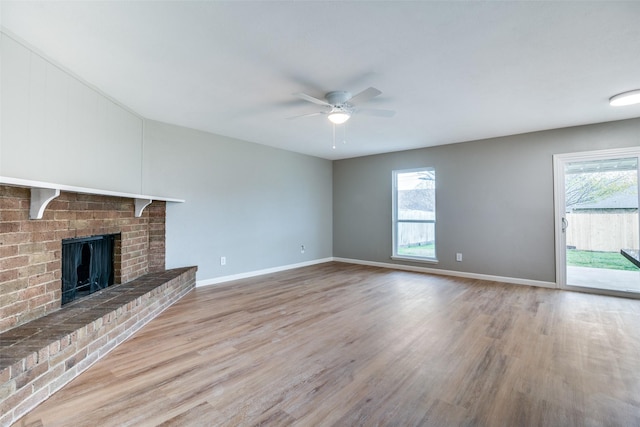 unfurnished living room featuring ceiling fan, a fireplace, and light hardwood / wood-style floors