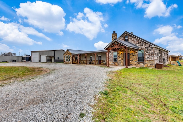 view of front facade featuring a front yard, a garage, and an outdoor structure