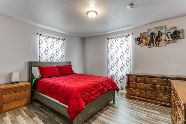 bedroom with light hardwood / wood-style flooring and a textured ceiling