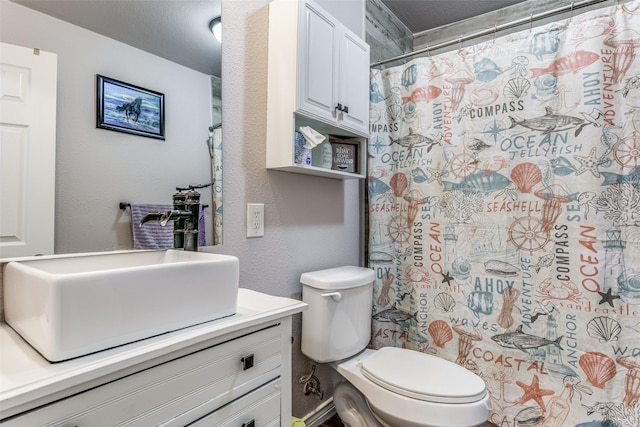 bathroom featuring walk in shower, vanity, and toilet