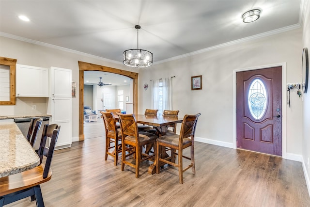 dining space featuring ornamental molding, an inviting chandelier, and light hardwood / wood-style flooring