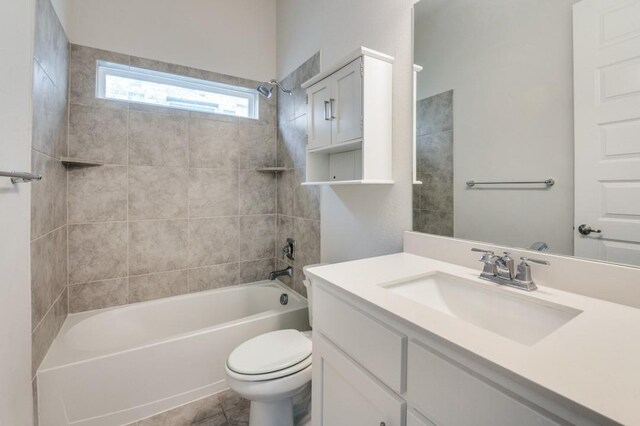 full bathroom featuring tile patterned floors, vanity, tiled shower / bath combo, and toilet