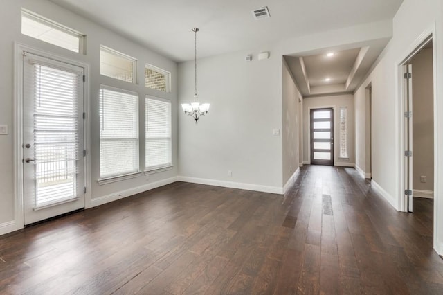 foyer with dark wood-type flooring and a notable chandelier