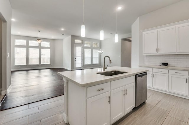 kitchen with dishwasher, a center island with sink, hanging light fixtures, and a healthy amount of sunlight