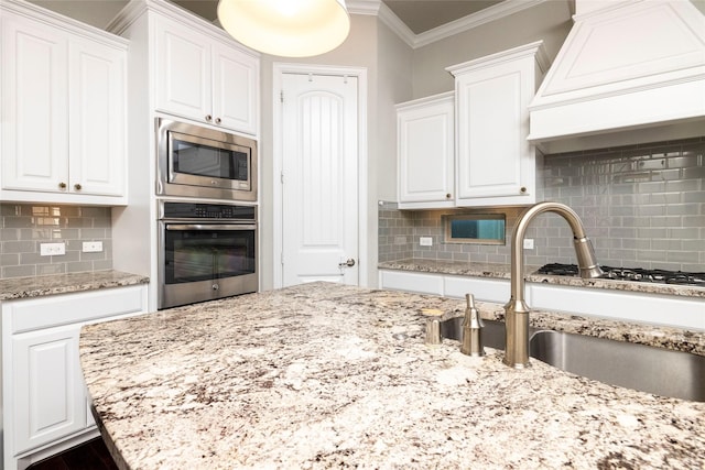 kitchen featuring white cabinets, custom exhaust hood, stainless steel appliances, and tasteful backsplash