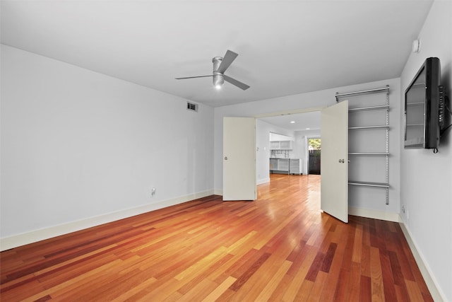 unfurnished living room with ceiling fan and wood-type flooring