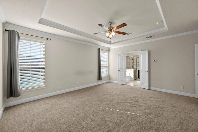 unfurnished bedroom with light carpet, ensuite bathroom, ornamental molding, a raised ceiling, and ceiling fan