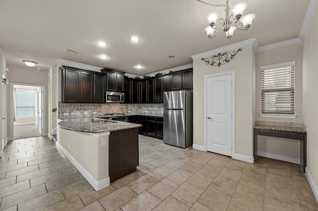 kitchen featuring backsplash, crown molding, pendant lighting, stone countertops, and appliances with stainless steel finishes