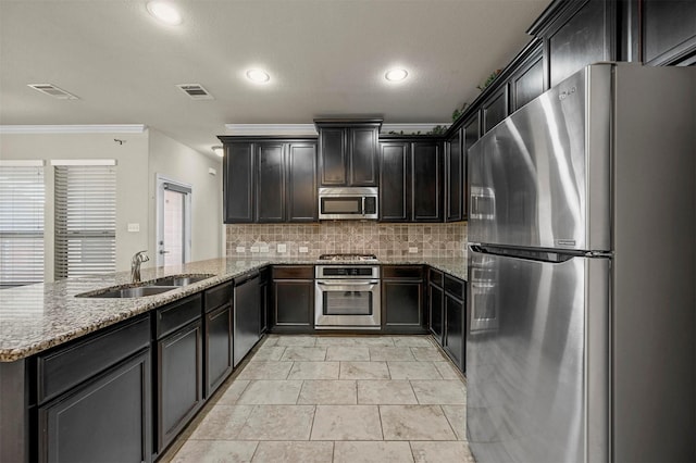 kitchen featuring sink, crown molding, light stone countertops, kitchen peninsula, and stainless steel appliances