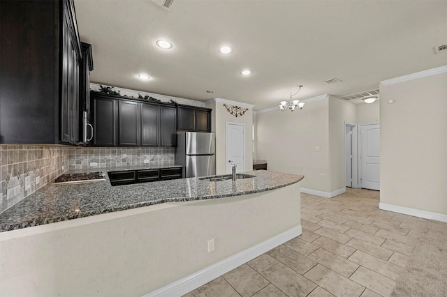 kitchen with sink, stainless steel appliances, dark stone counters, and tasteful backsplash