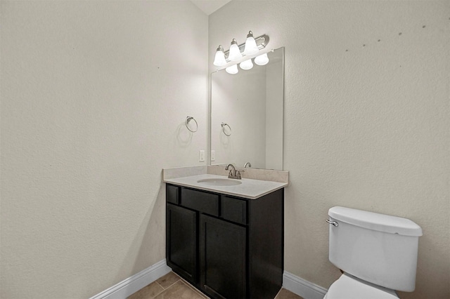 bathroom with tile patterned flooring, vanity, and toilet