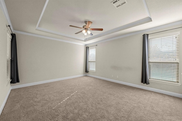 carpeted empty room featuring a raised ceiling, ceiling fan, and ornamental molding