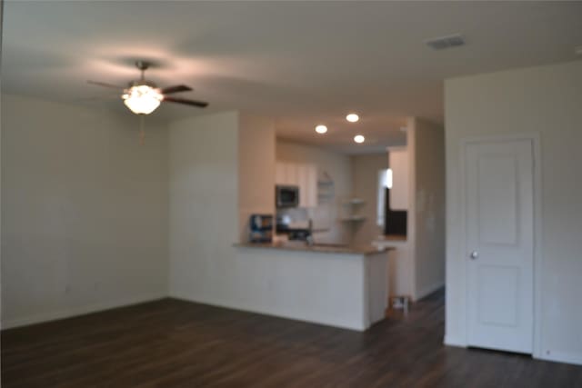 living room featuring dark wood-type flooring and ceiling fan