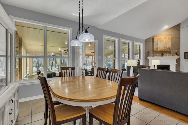 tiled dining room featuring lofted ceiling and a textured ceiling