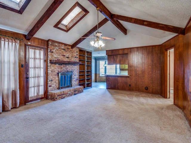 unfurnished living room featuring wood walls, a fireplace, light colored carpet, and a textured ceiling