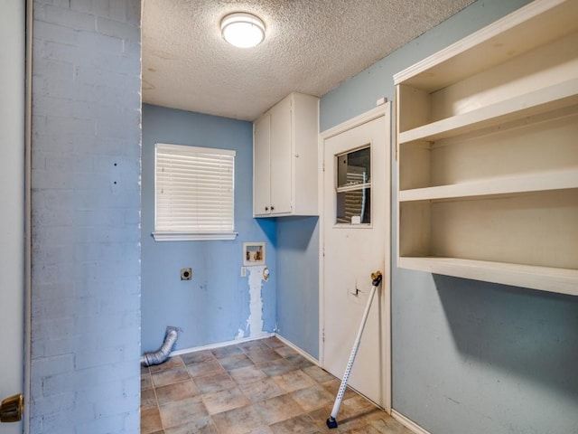 laundry area featuring hookup for an electric dryer, washer hookup, a textured ceiling, and cabinets