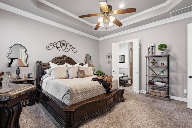 carpeted bedroom with ceiling fan, connected bathroom, ornamental molding, and a raised ceiling