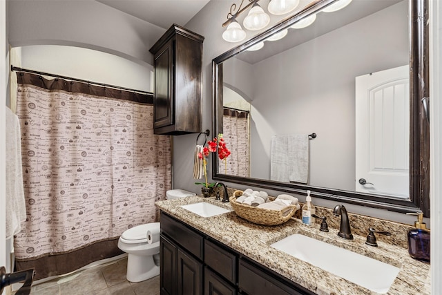 bathroom with tile patterned floors, vanity, toilet, and walk in shower