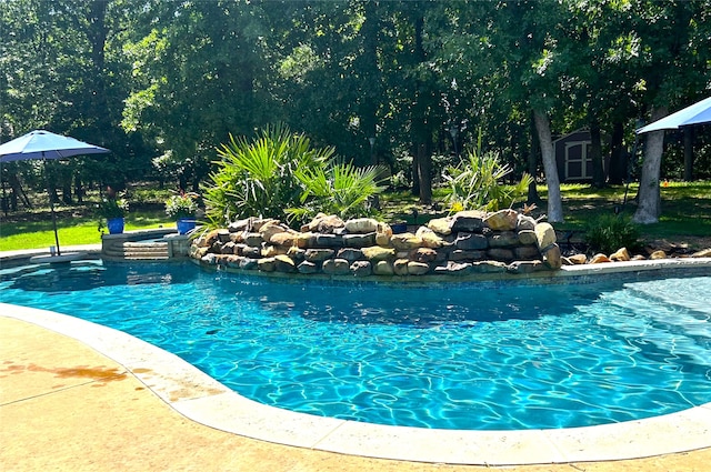 view of pool with an in ground hot tub