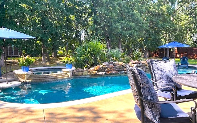 view of pool with an in ground hot tub and a patio area