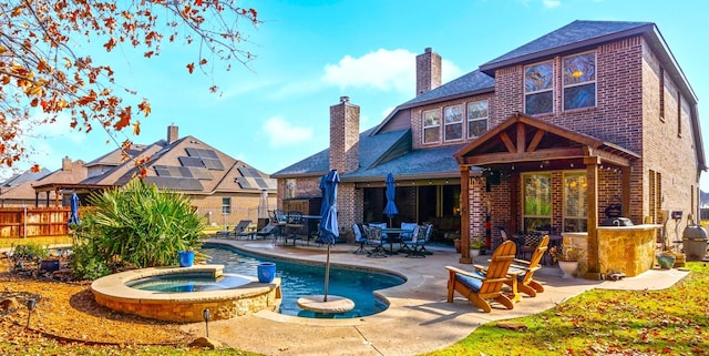 back of house featuring a pool with hot tub and a patio