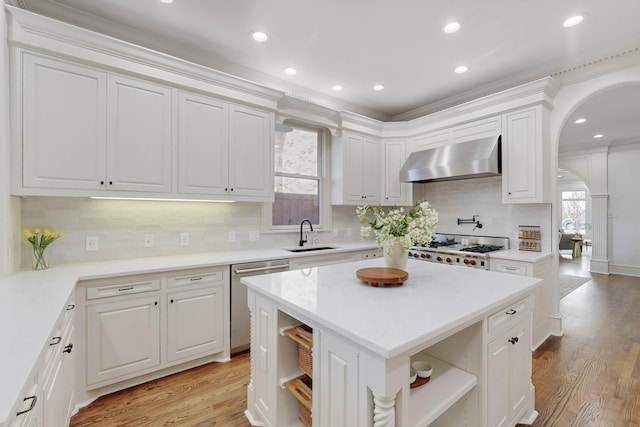 kitchen featuring appliances with stainless steel finishes, plenty of natural light, white cabinetry, and exhaust hood