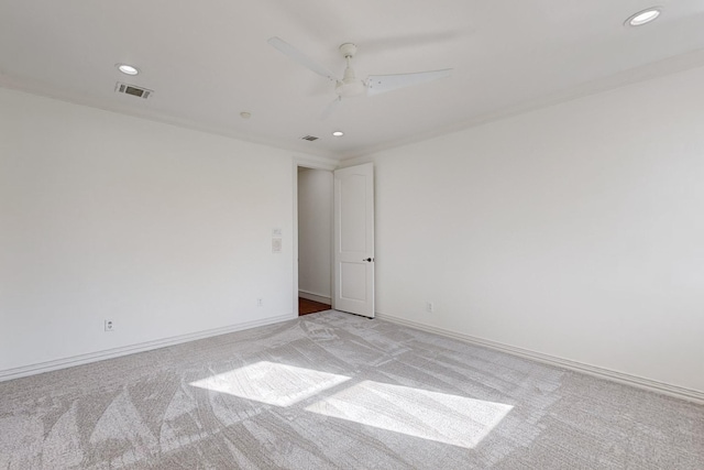 empty room featuring ceiling fan and light colored carpet