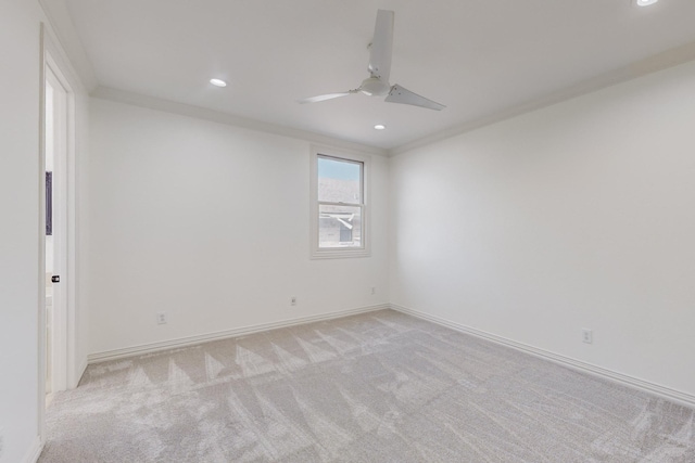 empty room featuring light carpet, ceiling fan, and crown molding