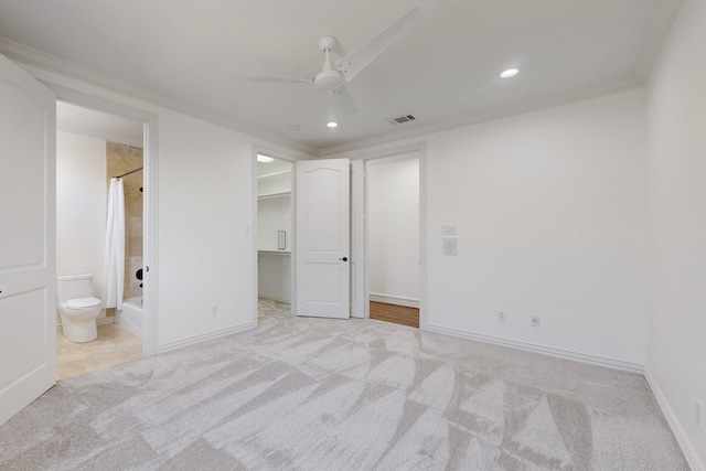 unfurnished bedroom with ensuite bath, light colored carpet, ceiling fan, a spacious closet, and a closet