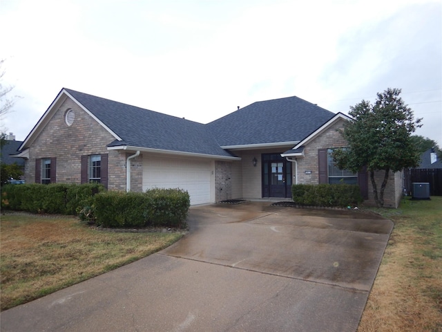 ranch-style home featuring a garage, central AC, and a front yard