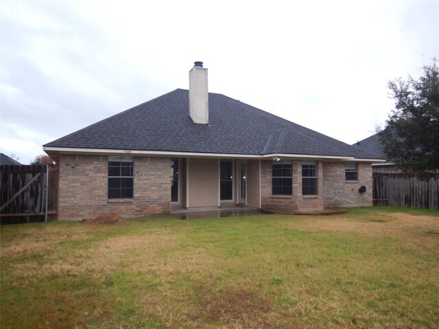 rear view of house featuring a yard