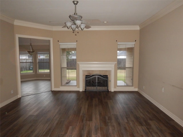 unfurnished living room featuring dark wood-type flooring, ceiling fan, ornamental molding, and a fireplace