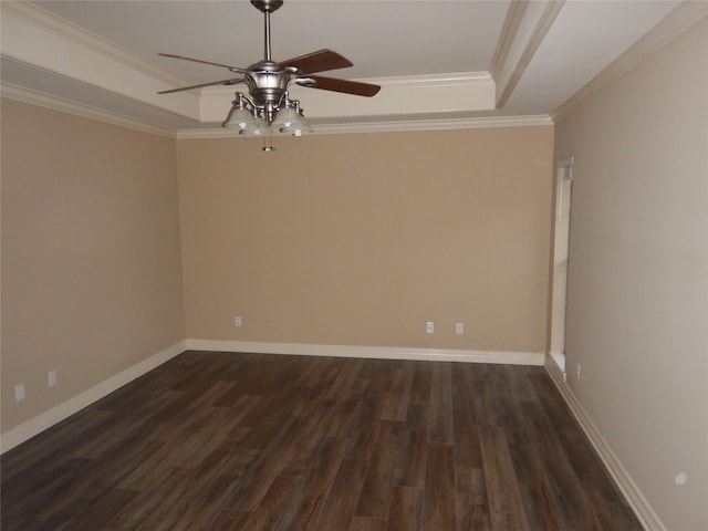 empty room featuring crown molding, dark wood-type flooring, ceiling fan, and a tray ceiling