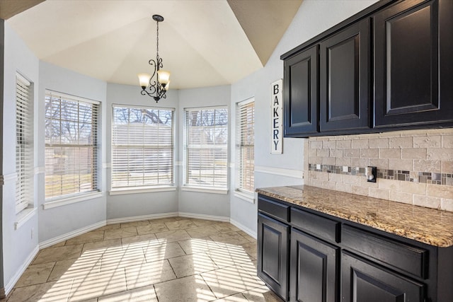 kitchen with backsplash, an inviting chandelier, hanging light fixtures, vaulted ceiling, and light tile patterned floors