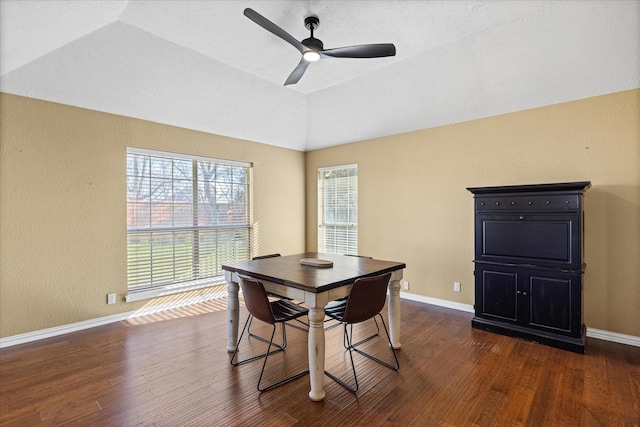 dining space with lofted ceiling, dark wood-type flooring, a ceiling fan, and baseboards