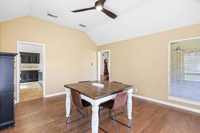 dining room featuring lofted ceiling, visible vents, and wood finished floors