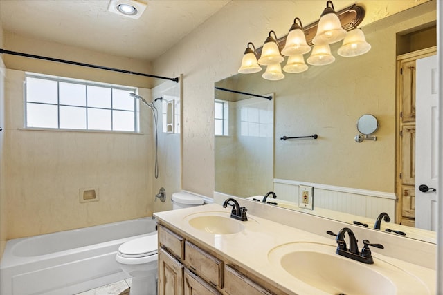 bathroom featuring toilet, shower / tub combination, a sink, and wainscoting