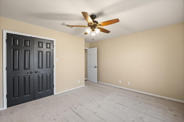 unfurnished bedroom with a closet, visible vents, a ceiling fan, light carpet, and baseboards