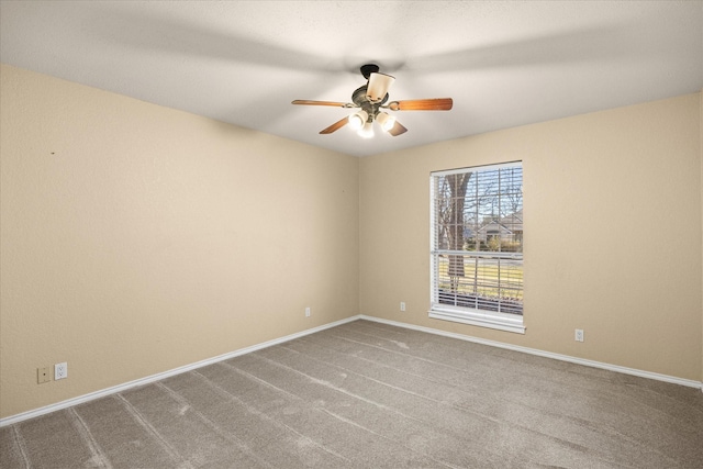 carpeted empty room with ceiling fan and baseboards