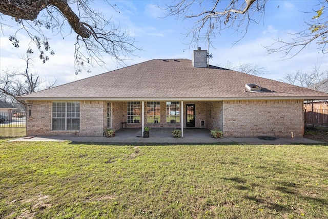 rear view of house featuring a yard, brick siding, and a patio