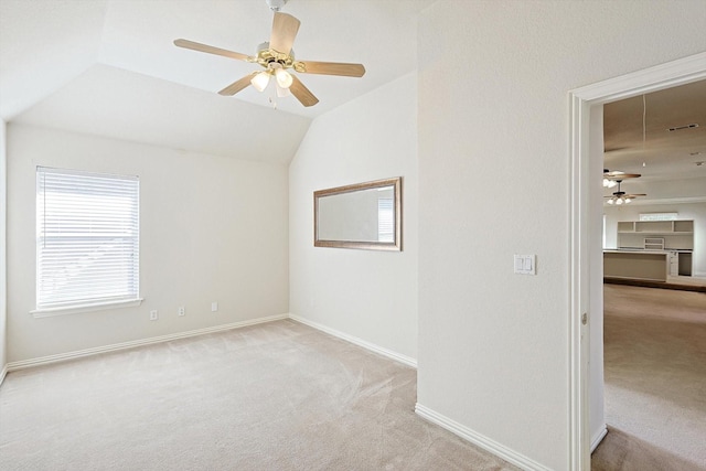 carpeted empty room featuring vaulted ceiling and ceiling fan