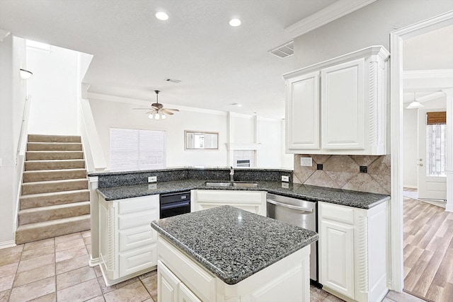 kitchen with ceiling fan, sink, a center island, kitchen peninsula, and ornamental molding