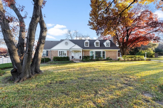 cape cod home featuring a front yard