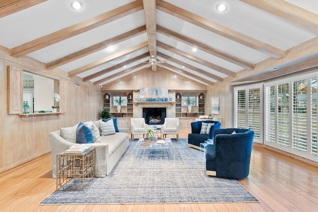 living room with ceiling fan, lofted ceiling with beams, and light wood-type flooring