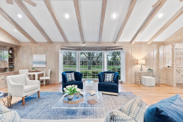 living room featuring vaulted ceiling with beams, wood walls, hardwood / wood-style floors, and ceiling fan