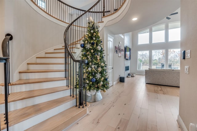 stairway featuring a towering ceiling and hardwood / wood-style floors