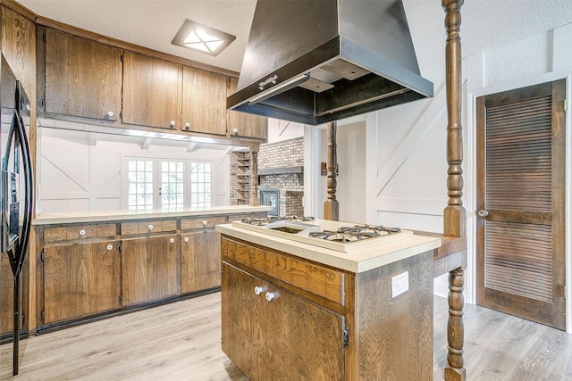 kitchen with island range hood, light hardwood / wood-style flooring, white gas cooktop, and a center island