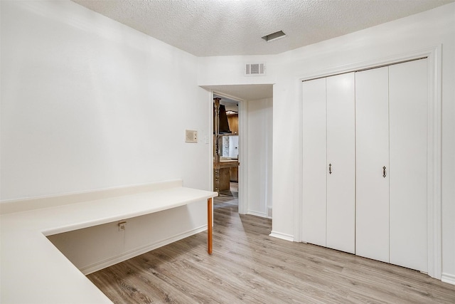 interior space with light hardwood / wood-style floors and a textured ceiling